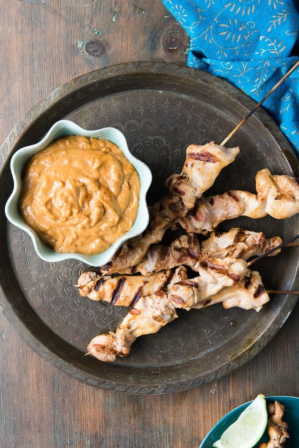 Grilled Chicken Thigh Satay with Peanut Dipping Sauce on brass tray
