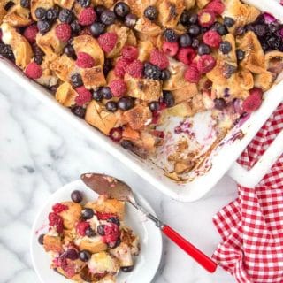 Baking pan of Overnight French Toast Casserole in Red, White and Blue with a single serving on white plate