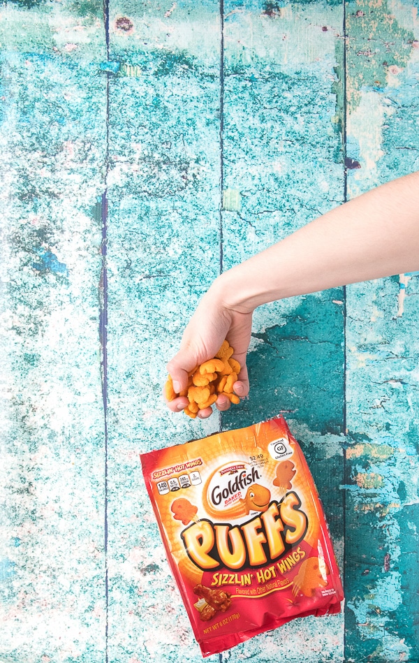 Child\'s Hand picking up gluten-free Goldfish Puffs 