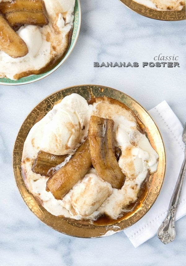Classic Bananas Foster recipe. Boozy caramelized flambeed bananas served hot over scoops of cold vanilla ice cream! 