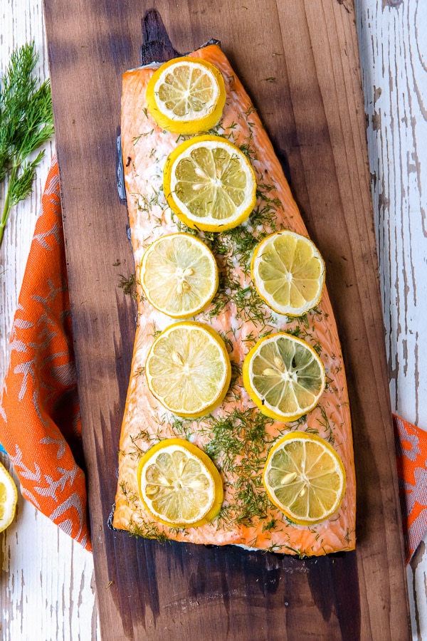 Charred cedar plank salmon cooked with dill and lemon slices