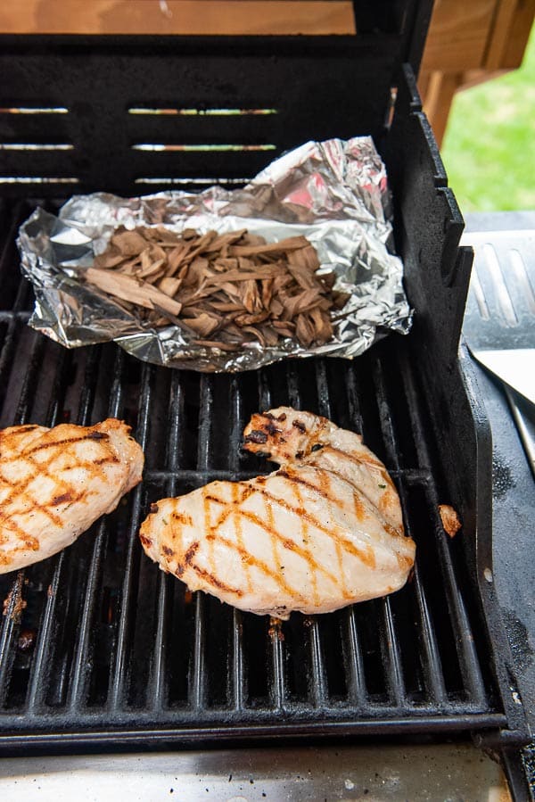 chicken breasts grilling with wood chips 