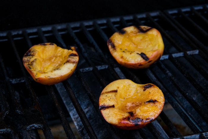 Grilling peaches on barbecue