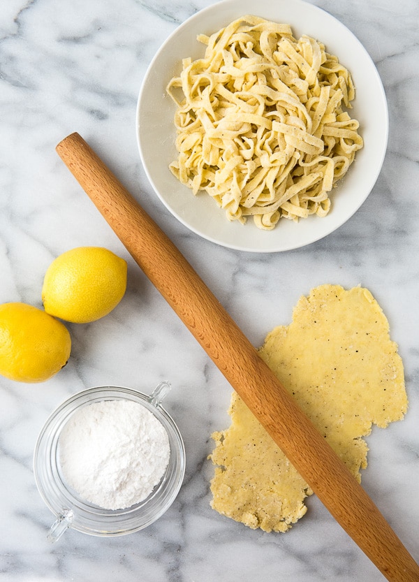 Making Homemade Gluten-Free Lemon Pepper Fettuccine Pasta with rolling pin 