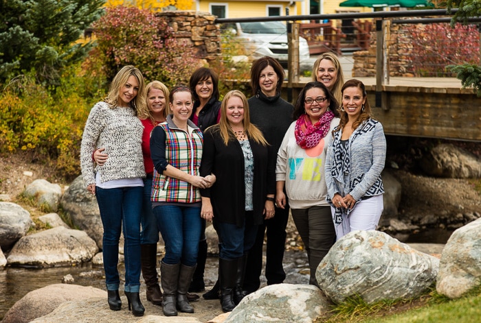 A group of people posing for a photo in front of a rock