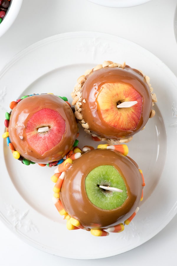 red and green apples dipped into caramel with sticks