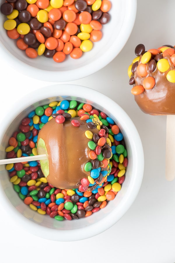 Caramel Apple rolled in a bowl of M & Ms