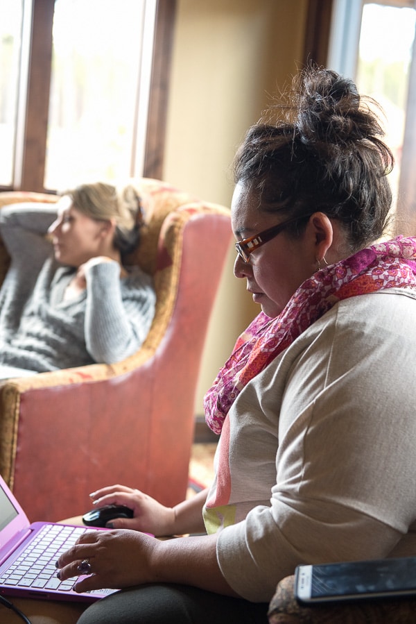 A woman sitting at a table using a laptop computer