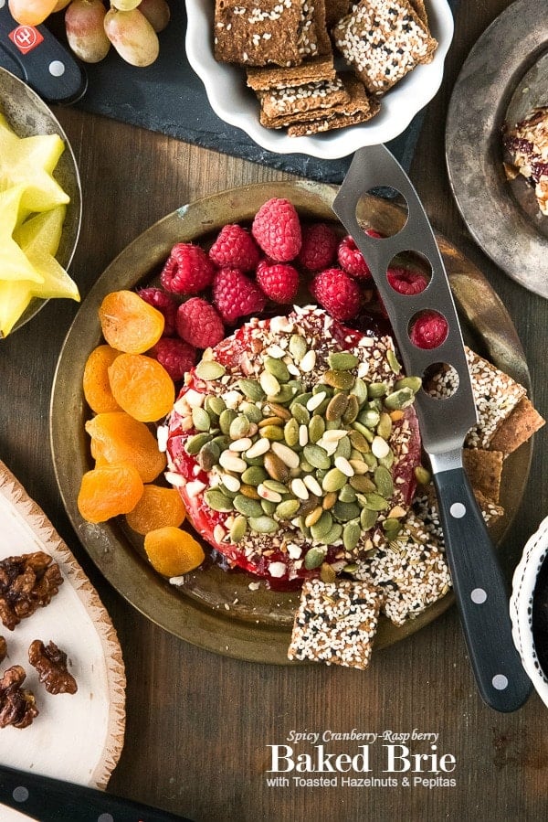 Spicy Cranberry-Raspberry Baked Brie with Toasted Hazelnuts and Pepitas