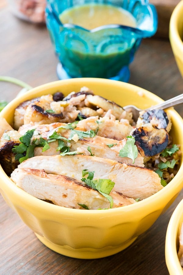 Cuban Garlic Chicken Bowls with Cuban Black Beans &amp; Rice, Fried Plantains &amp; Mojo Sauce served in a bright yellow bowl