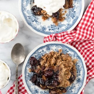 2 plates of Slow Cooker Cherry Spice Cake Cobbler, one with ice cream on top