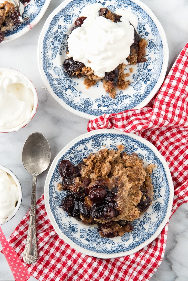 2 plates of Slow Cooker Cherry Spice Cake Cobbler, one with ice cream on top