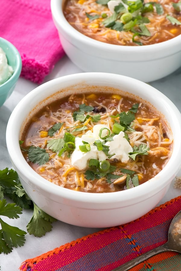 Slow Cooker Mexican Chicken and Rice Soup close up with shredded cheese and sour cream