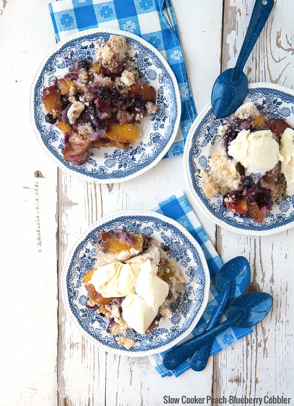 Slow Cooker Peach-Blueberry Cobbler with French Vanilla Ice Cream on blue and white plates