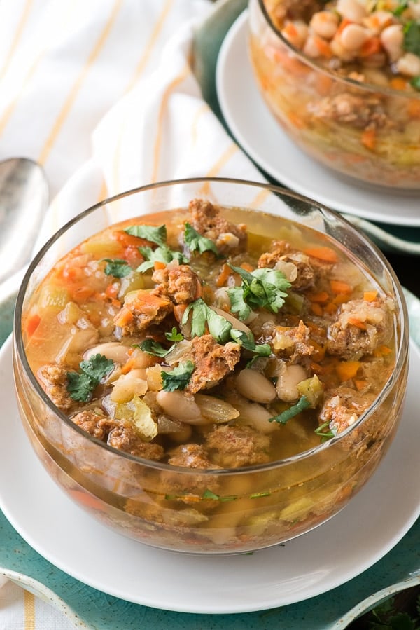 Slow Cooker Spicy Chorizo Green Chile Cannellini Bean Soup in a glass soup bowl