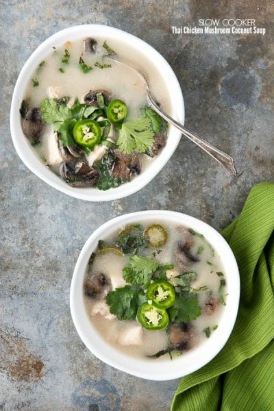 titled photo - 2 bowls of Slow Cooker Thai Chicken Mushroom Coconut Soup on a granite background.