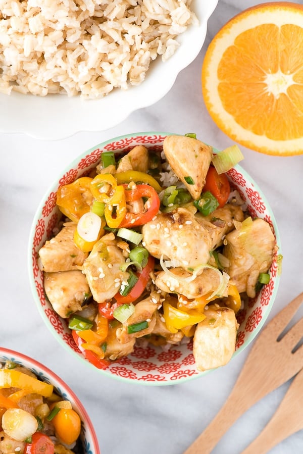 overhead shot of a bowl of Spicy Ginger Chicken Stir Fry with a bowl of fluffy rice above it.