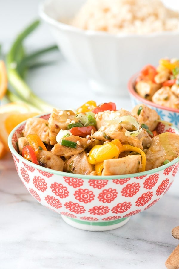 A decorative bowl filled with spicy ginger chicken stir fry