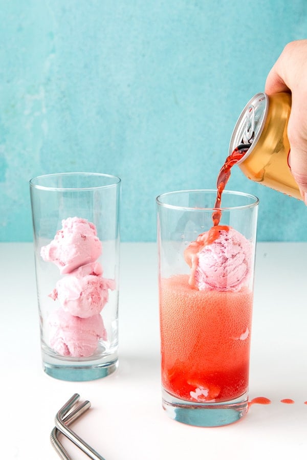 filling glasses of ice cream with strawberry soda for Strawberries and Cream Ice Cream Floats.