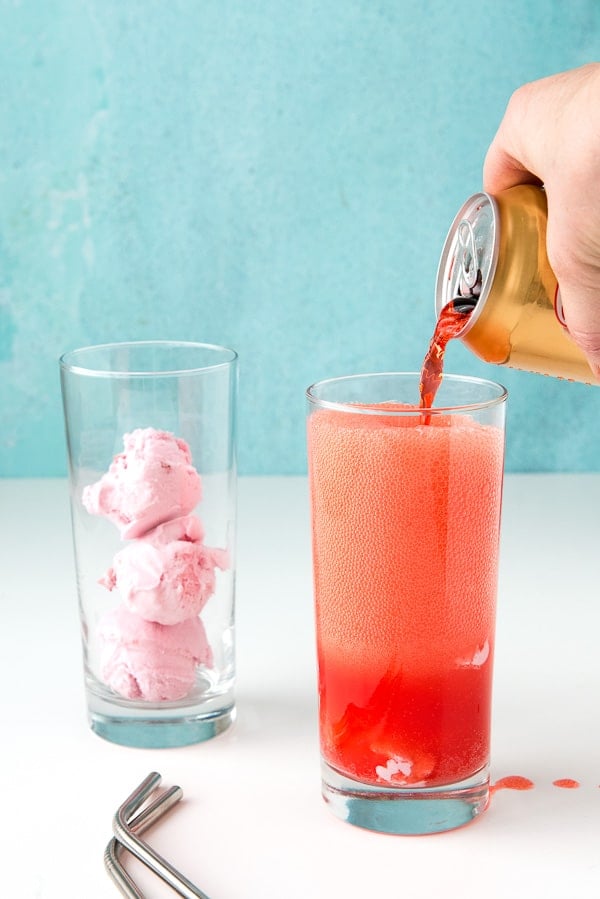 pouring strawberry soda into glass with ice cream balls