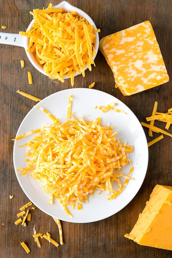 Mild Cheddar and Colby/Jack Cheese grated on a white plate