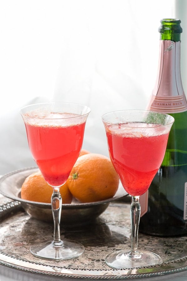 Two antique glasses of blood orange mimosas