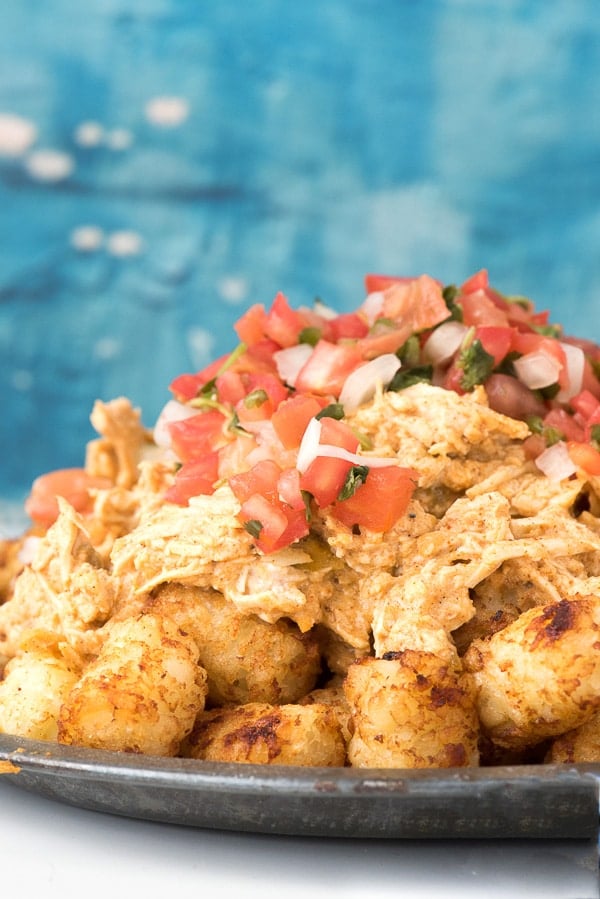 Green Chile Chicken Totchos smothered in creamy Green Chile Chicken and topped with pico de gallo