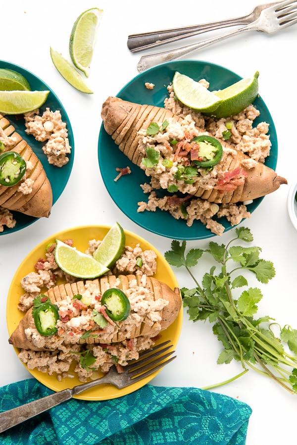 aqua and yellow dinner plates hold Hasselback style Sweet Potatoes topped with Creamed Chipotle Turkey