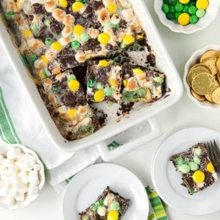 chocolate mint Leprechaun Bait Bars baked into a white baking dish, surrounded by some of the ingredients used to make them