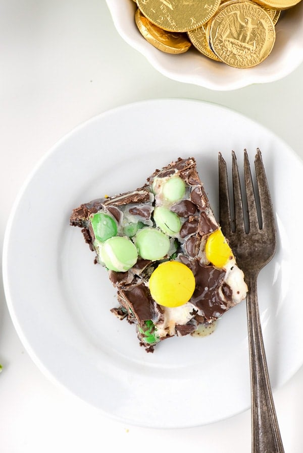 white dessert plate holding a slice of Leprechaun Bait Bar dessert and a fork.