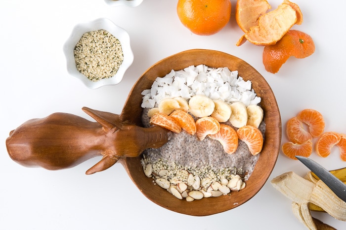 Roasted Banana Chia Pudding Breakfast Bowl surrounded by some of the fresh ingredients used to make it