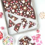 Rimmed baking sheet of Sweetheart Bark Valentine's Candy Chocolate Bark and candies