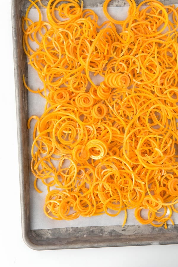 parchment paper lined baking sheet of spiralized Butternut Squash Noodles