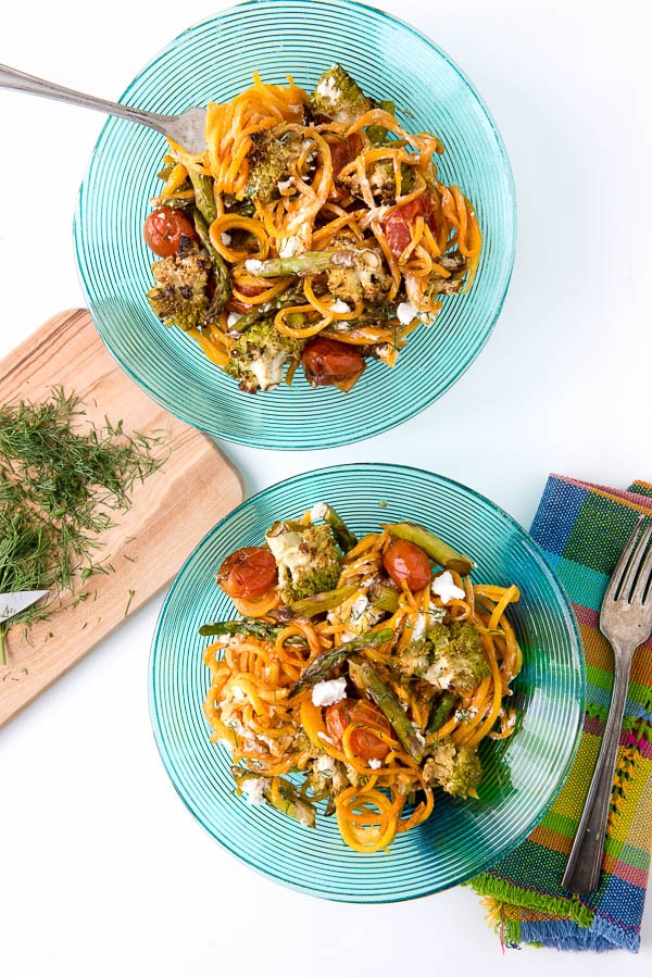 2 dinner plates with Balsamic Roasted Spring Vegetables on top of Butternut Squash Noodles 