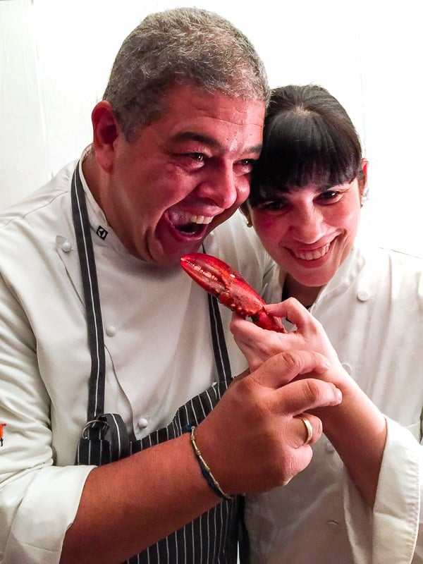 Chefs Alex and Sarah Martinez playfully cooking with crab claws