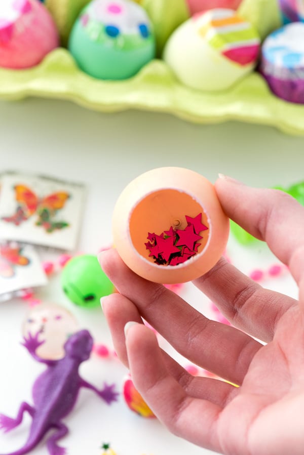 star confetti inside a dyed artifical egg with small toys in the background