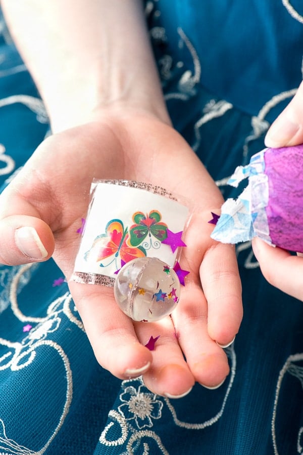 small toys and confetti from an opened Cascarones confetti egg in palm of a child\'s hand