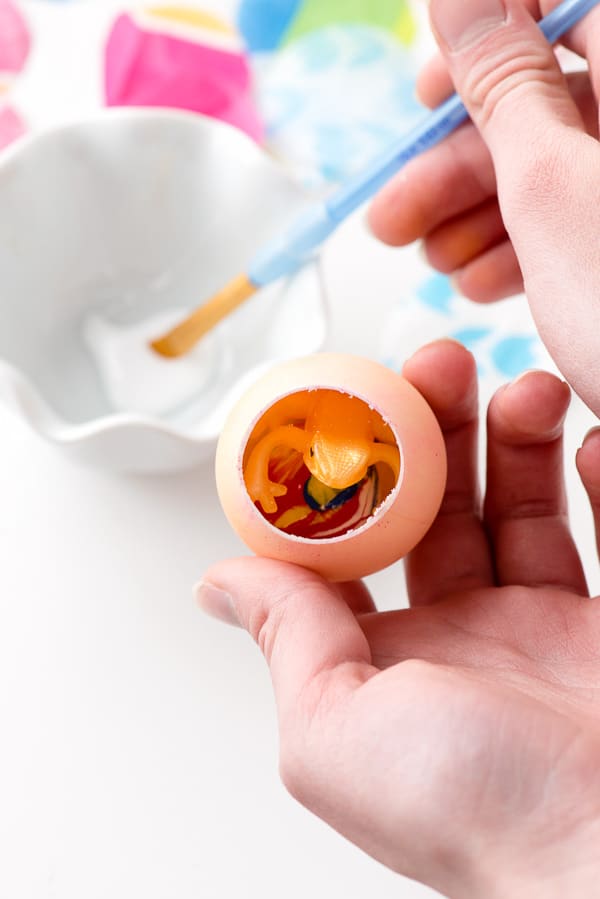 sealing a confetti egg with glue around the outside of the opening