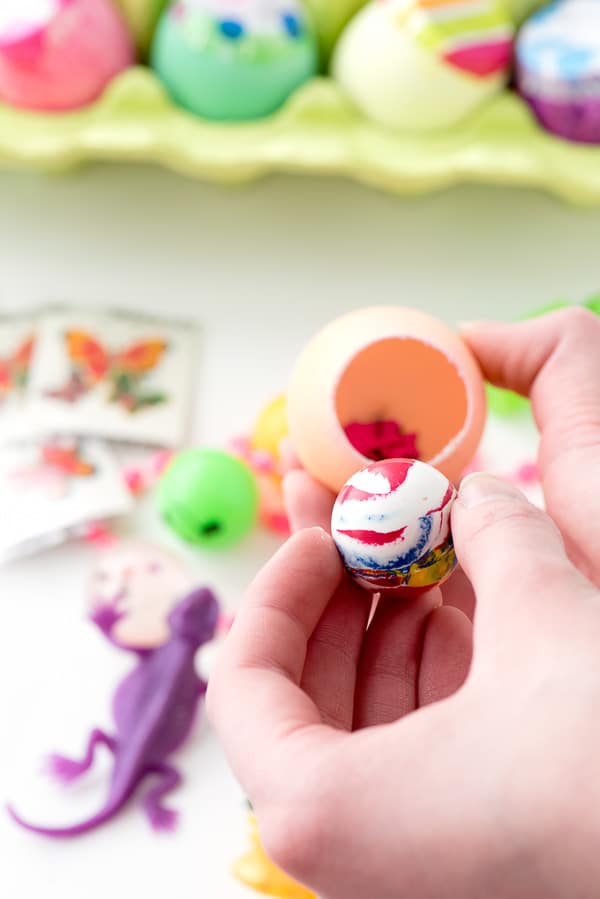 small ball being added inside a dyed egg with confetti