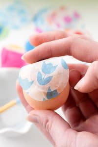 sealing the opening of a confetti egg with colorful tissue paper