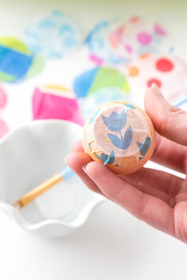 sealed homemade confetti egg with flower tissue paper on an orange egg