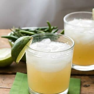 2 cocktail glasses of Thai Lemongrass Ginger Margaritas garnished with a fresh lime wedge