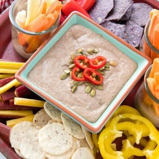 platter holding fresh vegetables and chips for dipping and a bowl of gluten free black bean green chile hummus dip