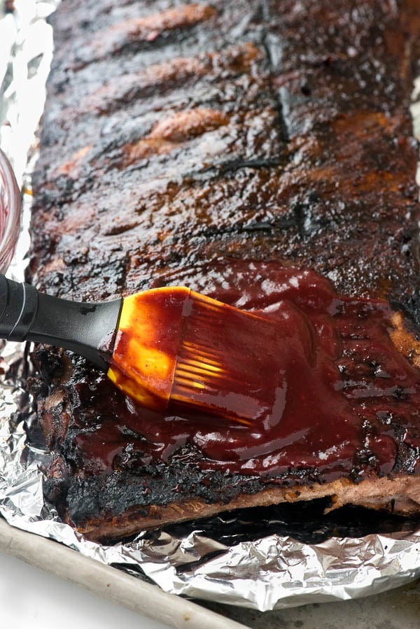 Brushing homemade Blueberry Whiskey Barbecue Sauce on St. Louis Ribs