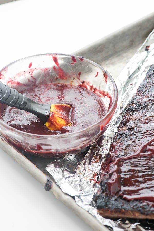 a bowl of blueberry whiskey homemade barbecue sauce with a grill basting brush in it.