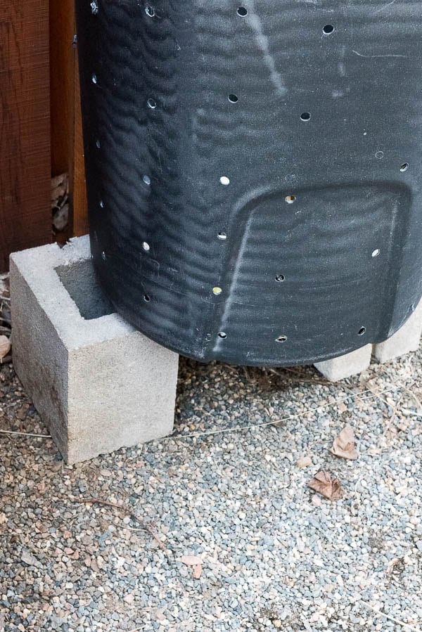 DIY compost can sitting on cinder blocks to allow for drainage and air circulation