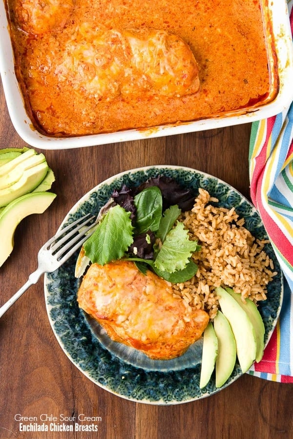 dinner plate with green chile chicken sour cream enchiladas, Mexican rice, and a small salad