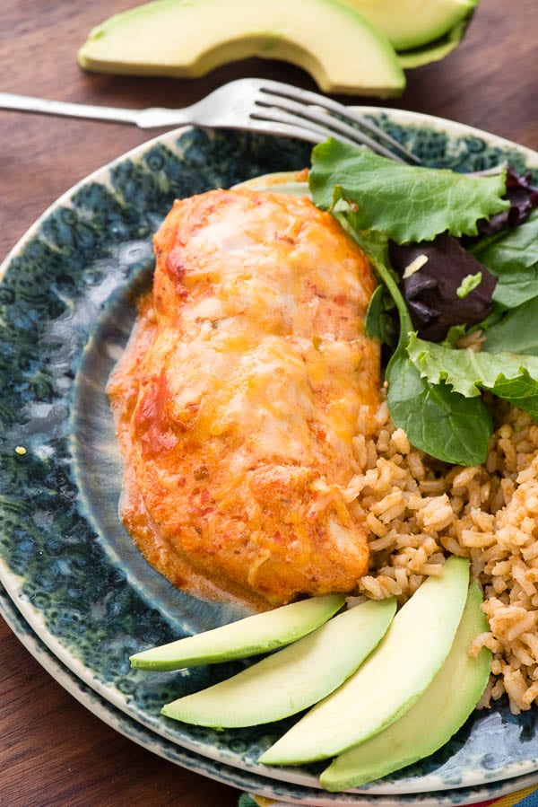 large chicken breasts with cheese and enchilada sauce on plate