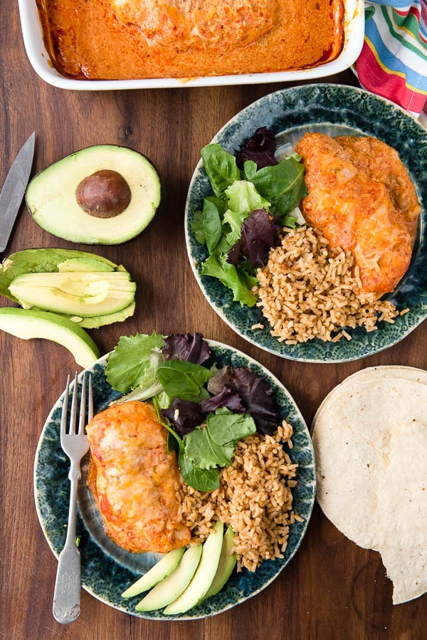 Mexican oven baked chicken breasts with rice and salad on green plates