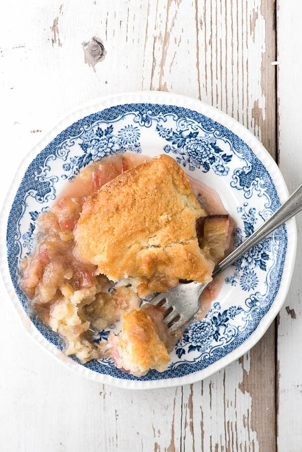 Blue and white vintage dessert plate with individual serving of Rhubarb Grunt, an Americana rhubarb dessert with baked biscuit topping 